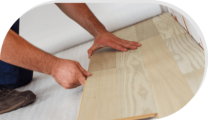 A person is cutting the wood on top of the floor.