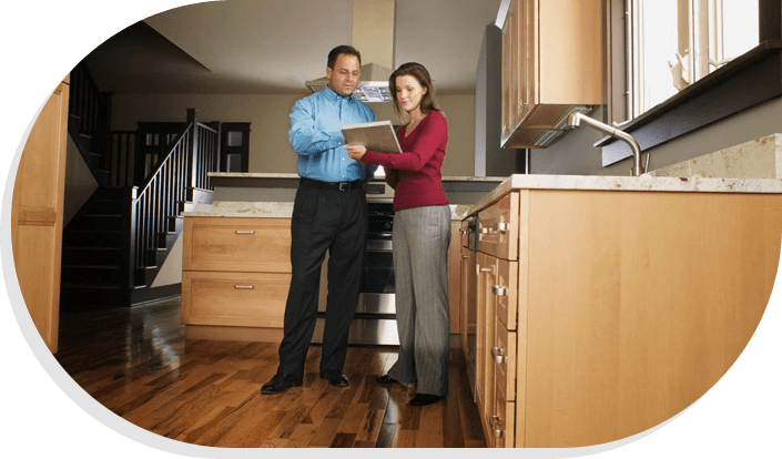 A man and woman standing in front of a kitchen.